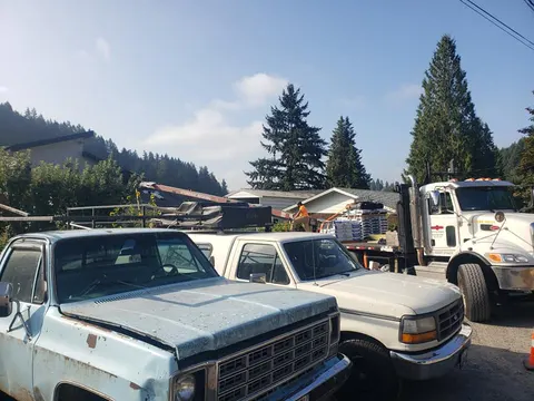 Ark Roofing & Renovations crew vehicles at an active job site in Tacoma, WA