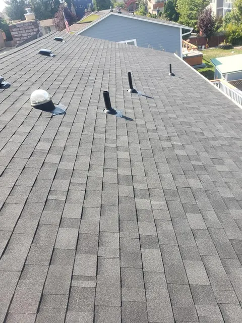 Completed dark gray roof with plumbing vents and solar tube, Tacoma roofing project