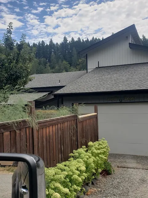 Modern home with dark board-and-batten siding installed by Ark Roofing & Renovations