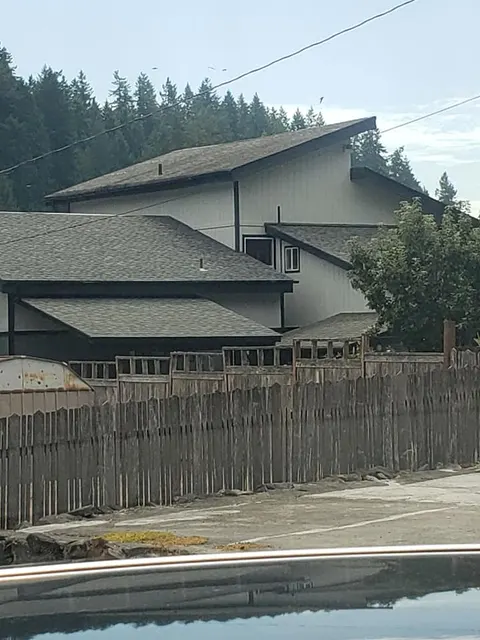 Multi-level dark painted home with multiple rooflines showing quality exterior paint work