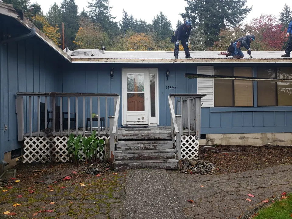 Roofing crew removing old materials during roof replacement project in Tacoma